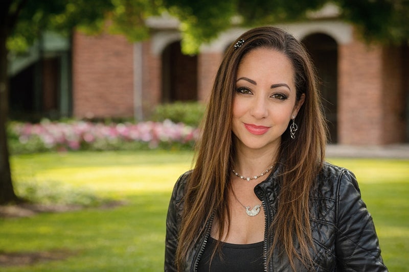 Woman with long brown hair wearing a black jacket